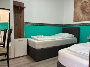two beds in a room with green walls at Mariazellerhof Room 015 in Sankt Pölten