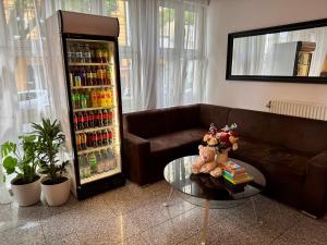 a living room with a couch and a drink refrigerator at Atlas Berlin Hotel in Berlin