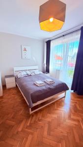 a bedroom with a large bed and a large window at MERKADO in Darlowko