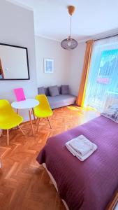 a bedroom with a bed and a table and chairs at MERKADO in Darlowko