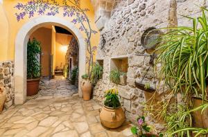a stone building with potted plants in a hallway at Tenuta Masseria del Gallo in Calimera