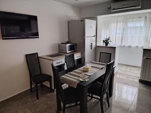a kitchen with a table and chairs and a microwave at Apartament Centru in Râmnicu Vâlcea
