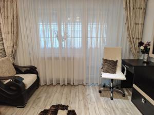 a bedroom with a bed and a desk and a chair at Apartament Centru in Râmnicu Vâlcea