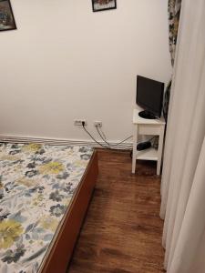 a bedroom with a bed and a desk with a tv at Apartament Centru in Râmnicu Vâlcea +4 photos