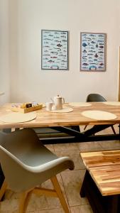 a wooden table with a chair and a wooden table with paintings at Penzion Ludor in Strážnice