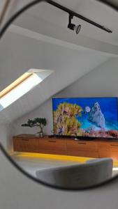a reflection of a television in a mirror at Square View Apartment Center Niksic in Nikšić