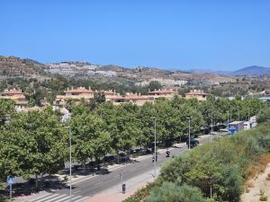 a street with trees and buildings in a city at Marina Serena in La Cala de Mijas