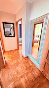 a room with a wooden floor and a mirror at MERKADO in Darlowko