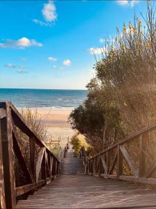 a wooden boardwalk leading to the beach at Hostal la Campa in Chiclana de la Frontera