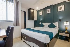 a bedroom with a large bed with a blue wall at Hotel O Nirsukh Palace in Navi Mumbai