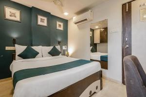 a bedroom with a large bed and a mirror at Hotel O Nirsukh Palace in Navi Mumbai +51 photos