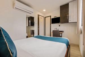a small room with a bed and a kitchen at Hotel O Nirsukh Palace in Navi Mumbai