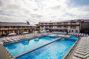 a hotel with a pool and chairs and a building at Золотий Павлін in Solotvyno