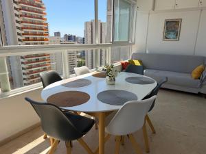 a living room with a table and chairs and a couch at Gemeleos22 in Benidorm
