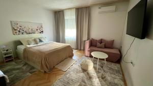 a small bedroom with a bed and a chair at Guest House Bosnian House in Sarajevo