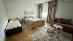 a small bedroom with a bed and a couch at Guest House Bosnian House in Sarajevo