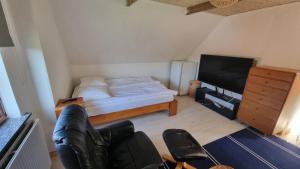 a small bedroom with a bed and a television at Casa del Amor in Hyldtofte