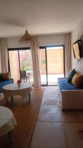 a living room with a blue couch and a table at APPARTEMENT surf camp pour les familles in Oualidia