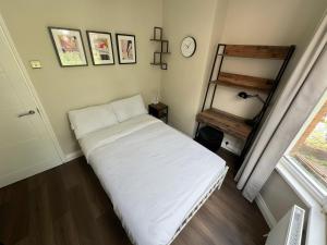 a bed in a room with a clock on the wall at Stylish 2BR Flat 3 Mins to Wembley Stadium in London +5 photos