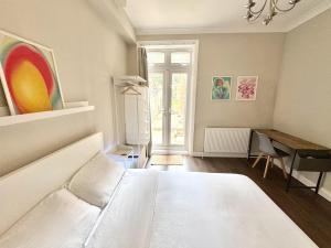 a bedroom with a bed and a desk and a window at Stylish 2BR Flat 3 Mins to Wembley Stadium in London