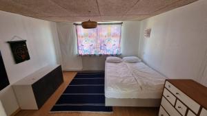 a small bedroom with a bed and a window at Casa del Amor in Hyldtofte