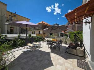 a patio with tables and chairs and umbrellas at Apartment Romić in Omiš