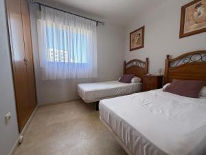 a bedroom with two beds and a window at Gemeleos22 in Benidorm +7 photos