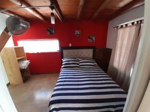 a bed in a room with a red wall at Los 2 Hermanos in Tanti +25 photos