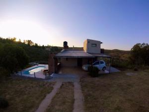 a house with a car parked next to a pool at Los 2 Hermanos in Tanti