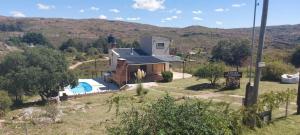 a small house with a swimming pool in a field at Los 2 Hermanos in Tanti