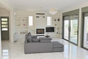 a living room with a couch and a tv at VILLA GALINI NAFPLIO with Panoramic View I in Nafplio