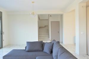 a living room with a gray couch in a white room at VILLA GALINI NAFPLIO with Panoramic View I in Nafplio +36 photos