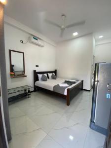 a bedroom with a bed and a mirror on the wall at NRT Beach Hotel in Trincomalee +7 photos