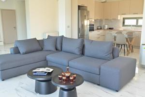 a living room with a blue couch and tables at VILLA GALINI NAFPLIO with Panoramic View I in Nafplio