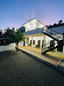 a house with a staircase in front of it at NRT Beach Hotel in Trincomalee