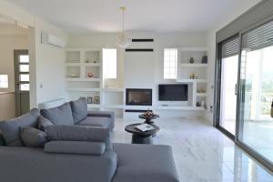 a living room with a couch and a tv at VILLA GALINI NAFPLIO with Panoramic View I in Nafplio