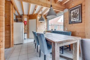 a dining room with a wooden table and blue chairs at Green House in Koudekerke
