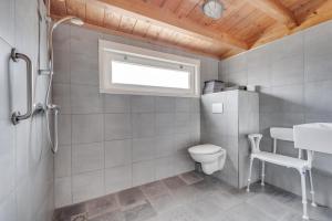 a bathroom with a toilet and a sink and a window at Green House in Koudekerke
