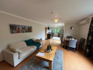 a living room with a couch and a table at Spacious peaceful apartment in Wellington
