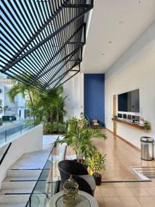 an office lobby with a glass ceiling and plants at Anah Suites by Las Flores Vacation Rentals in Playa del Carmen