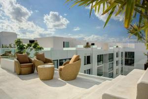 an outdoor patio with chairs and a building at Anah Suites by Las Flores Vacation Rentals in Playa del Carmen