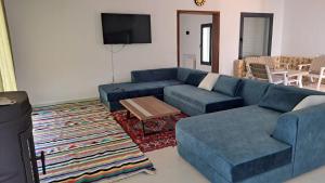 a living room with a blue couch and a table at Dar Zakia in Soliman