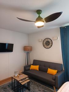 a living room with a couch and a ceiling fan at Studio avec parking gratuit in Cenon