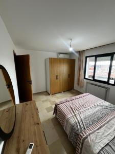 a bedroom with a bed and a wooden table at Sweethome in Ariana