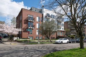 a white car parked in front of a brick building at Stunning Capitol Hill 1BD Condo in Seattle