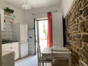 a kitchen with a table and a brick wall at ZIO DOMENICO Al Vicolo in Castellabate +1 photo