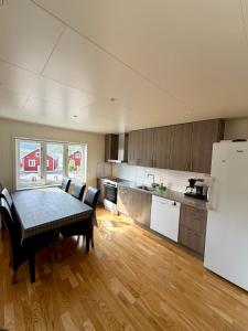 a large kitchen with a table and a refrigerator at ROOMS by Kåkern Bridge in Sund