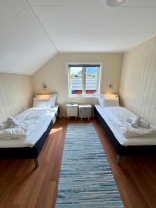a bedroom with two beds and a window at ROOMS by Kåkern Bridge in Sund