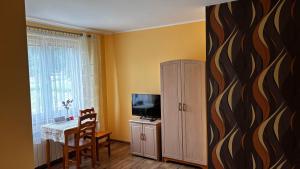 a living room with a television and a table with chairs at Łopiennik in Cisna