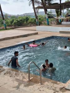 a group of people swimming in a swimming pool at Lake N Trails Exotic Glamping in Khālāpur